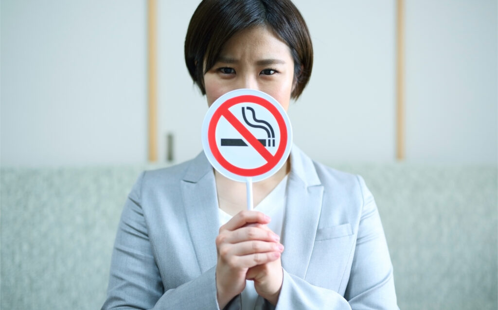 インプラント周囲炎の予防のために喫煙を勧める女性