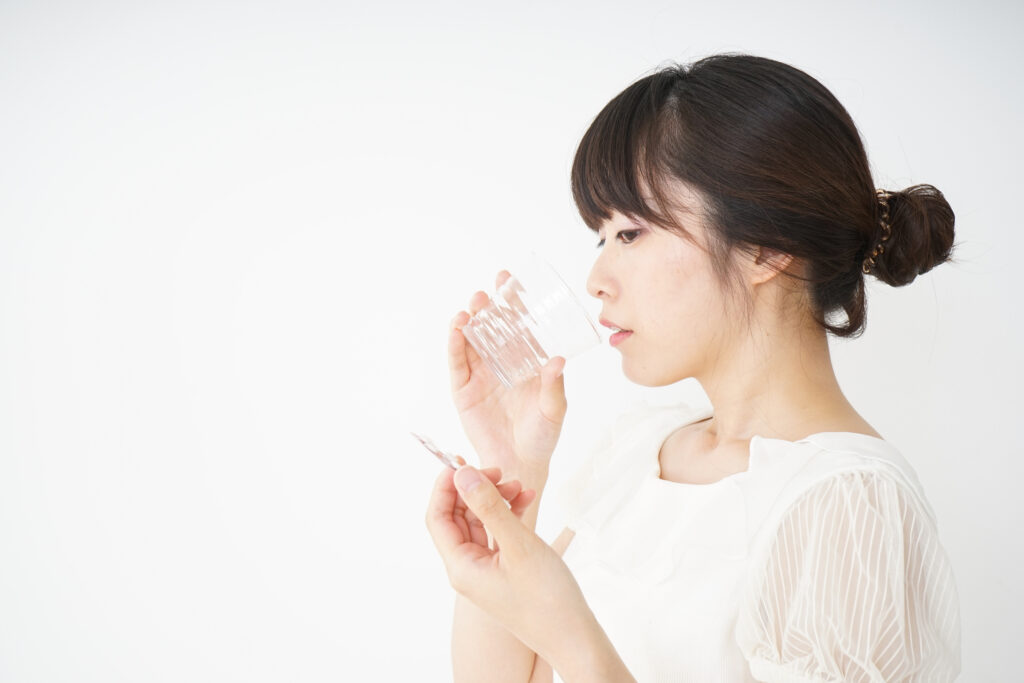 薬を飲む女性