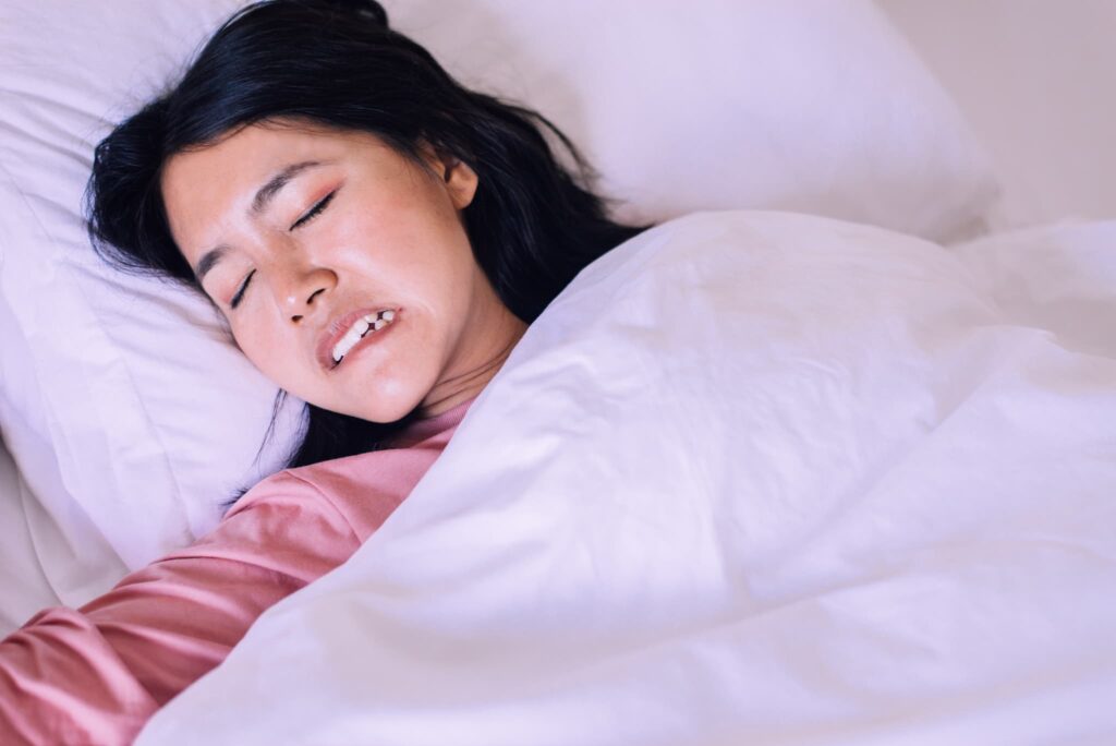 セラミックの歯が取れる原因である歯ぎしりをする女性