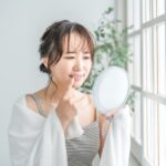セラミックで黒くなった歯茎を気にする女性