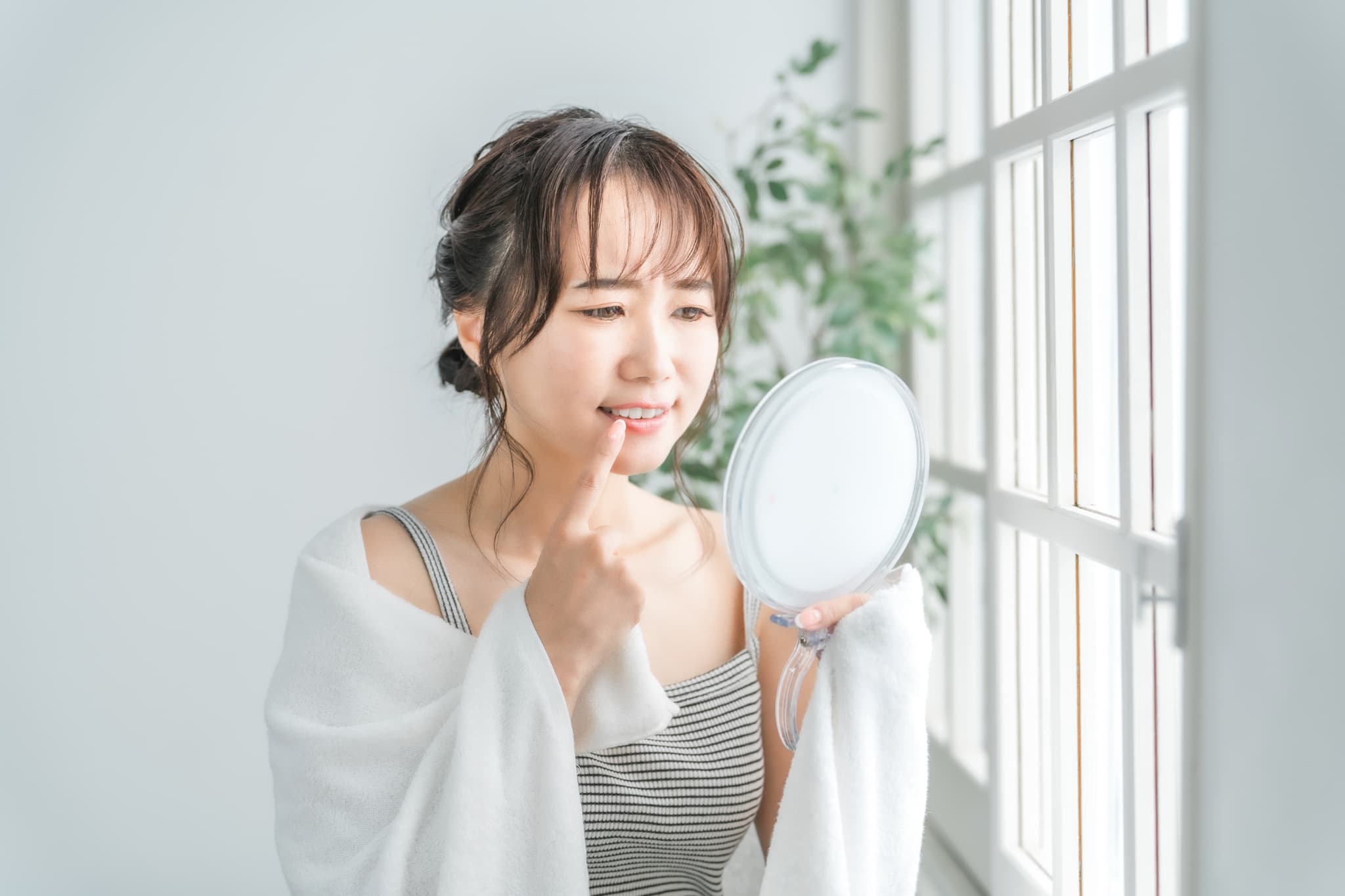 セラミックで黒くなった歯茎を気にする女性
