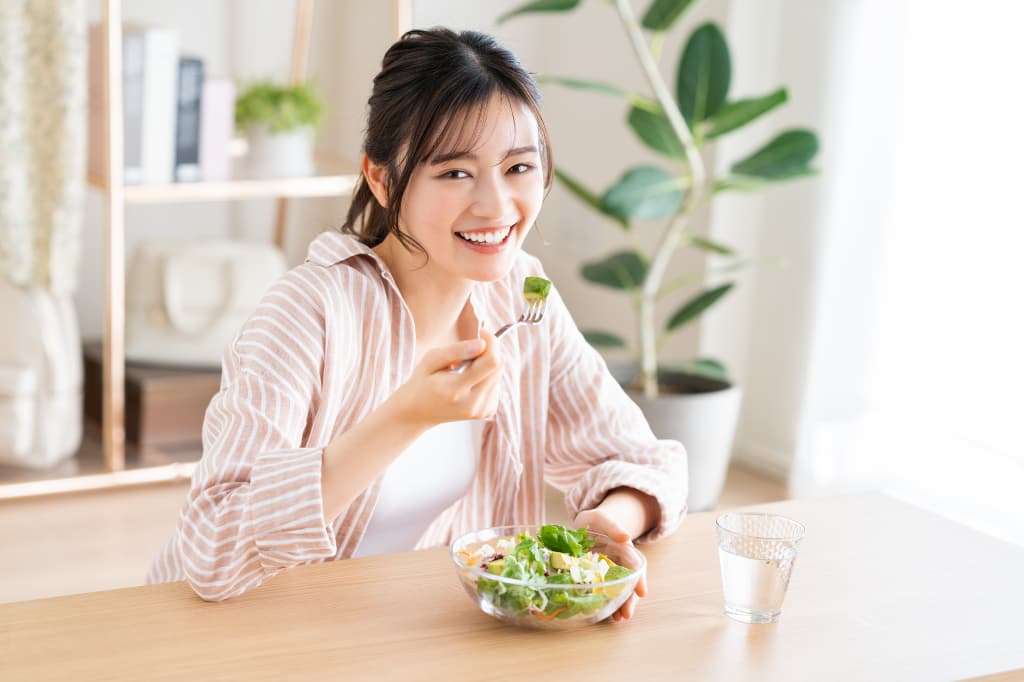 奥歯をセラミックにし笑顔で食事をいただく女性