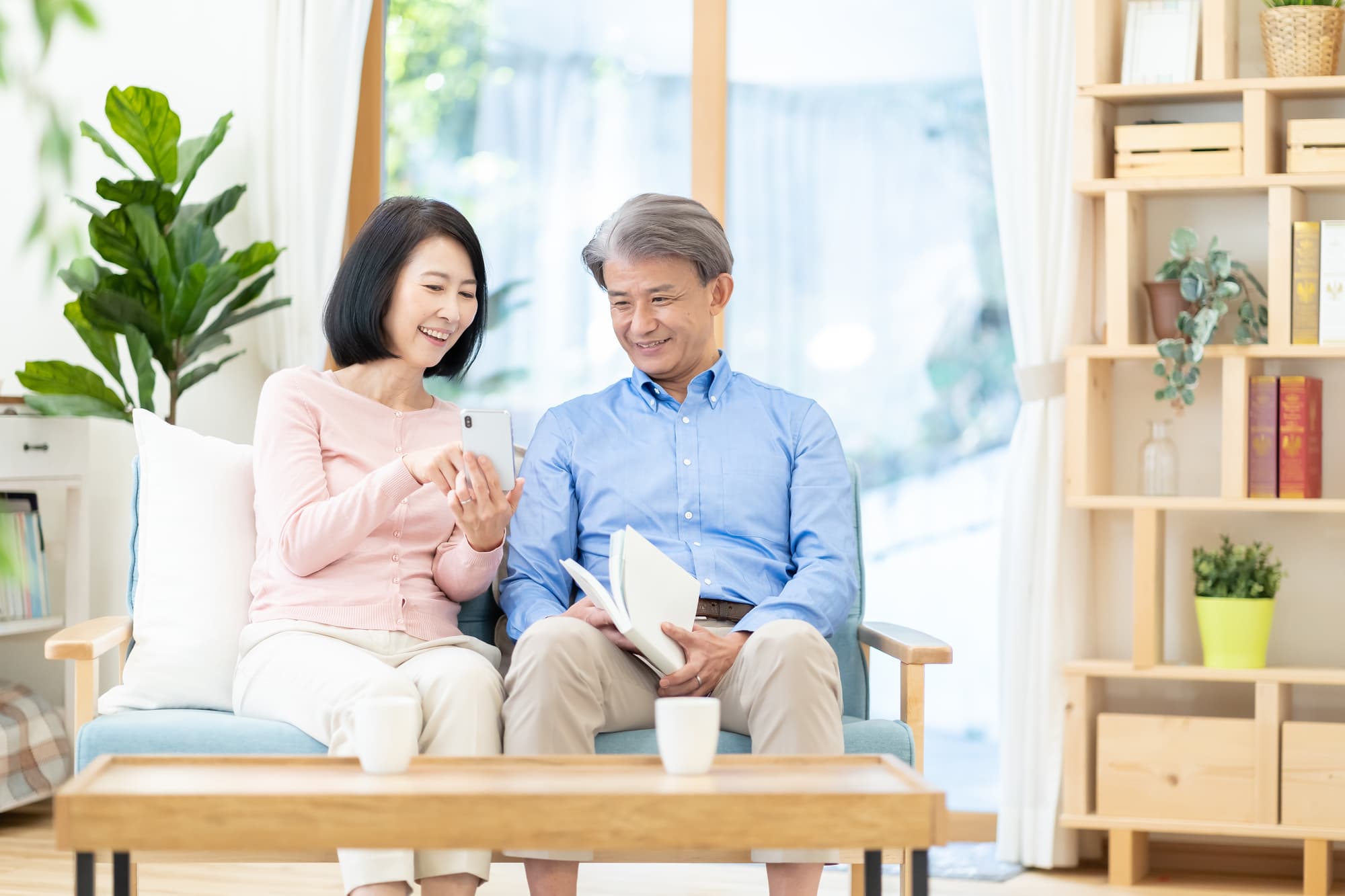 スマホを見ながら笑顔で仲良く会話する夫婦