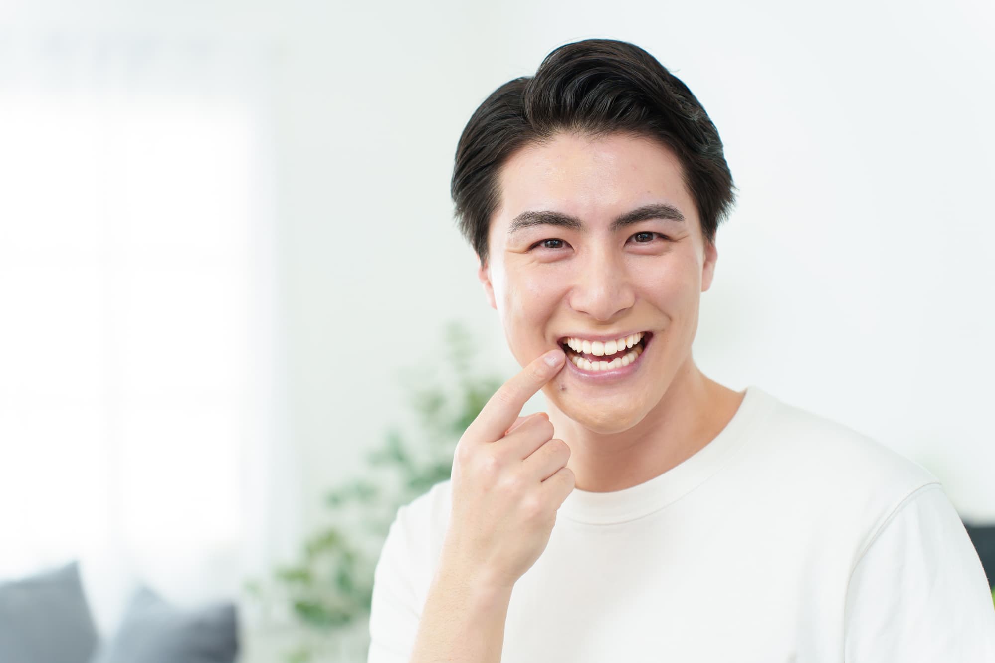 根管治療をした歯を指さして笑顔を見せる男性
