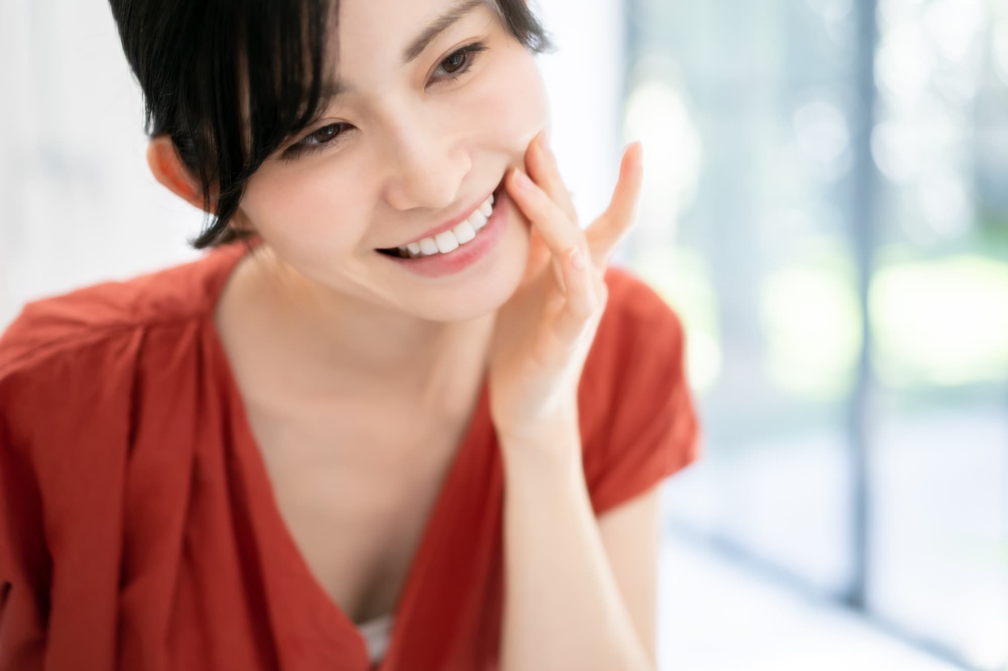 白い歯を鏡で確認して笑顔を見せる女性