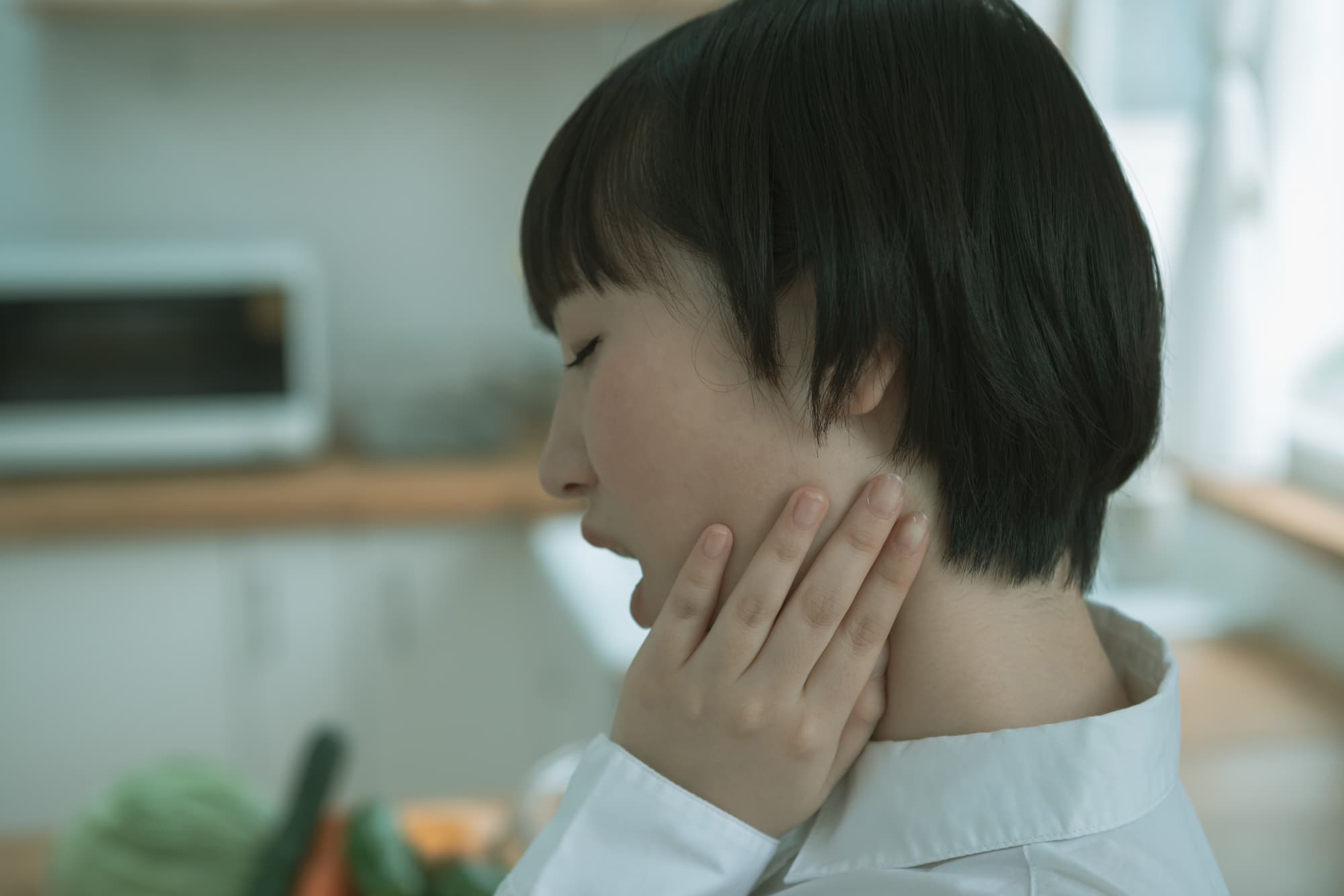 口が開けにくく痛そうな女性の横顔