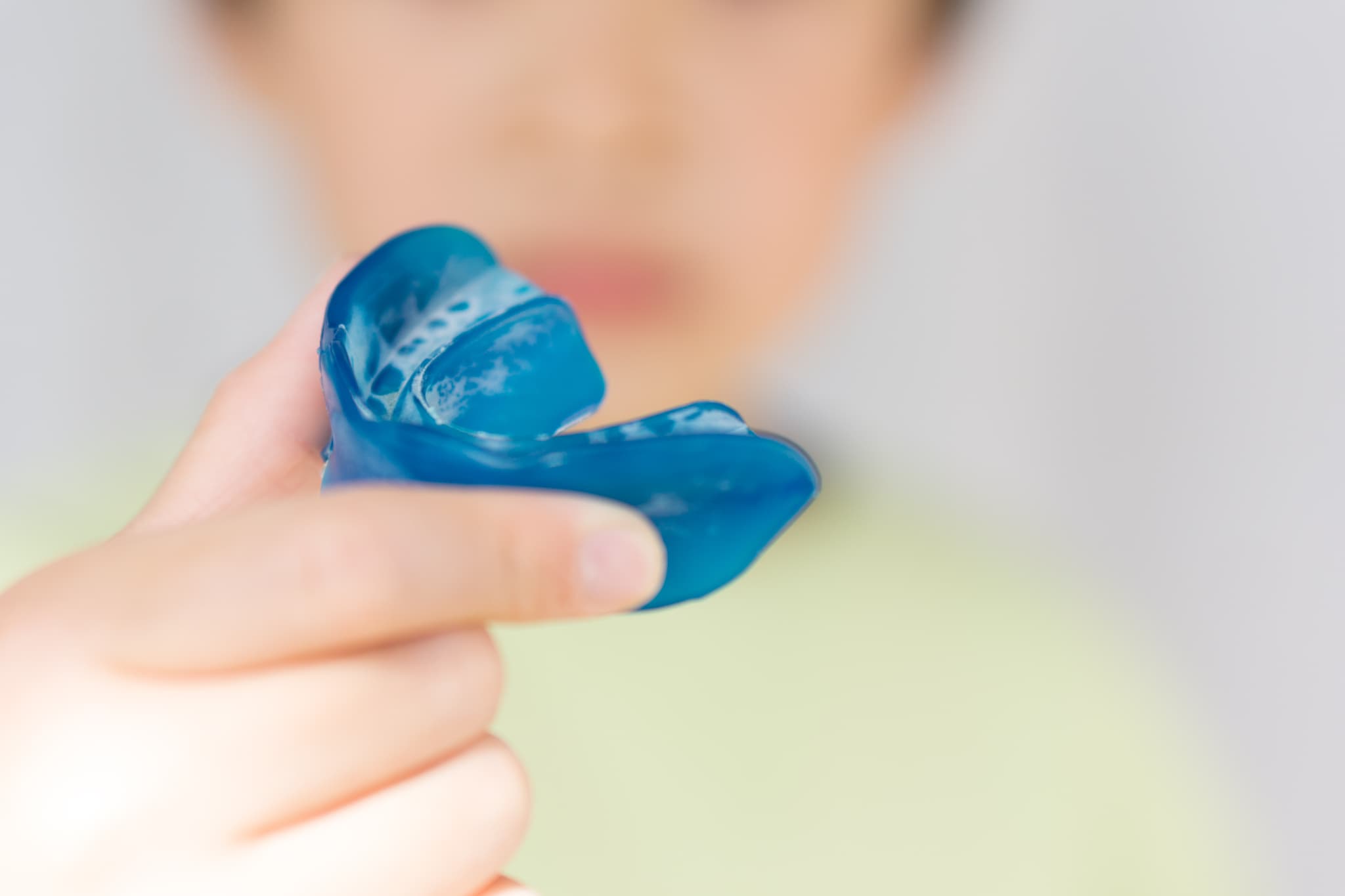 プレオルソの装置を持つ子どもの手