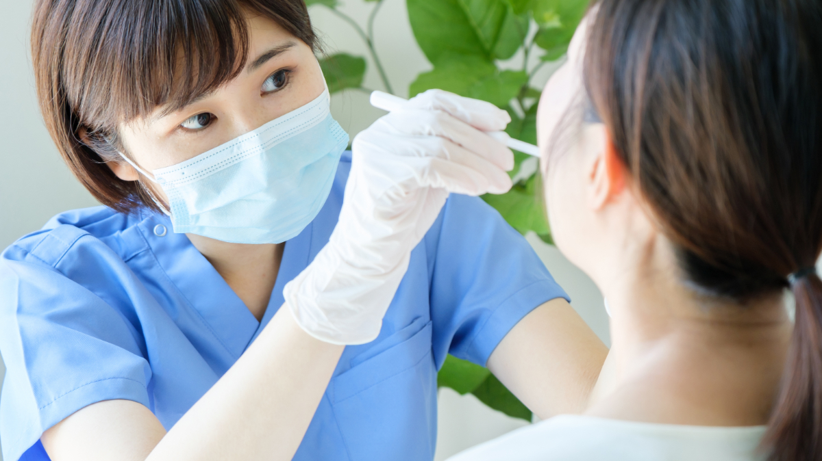 銀歯の下が虫歯になっていないかを確認している歯科医師