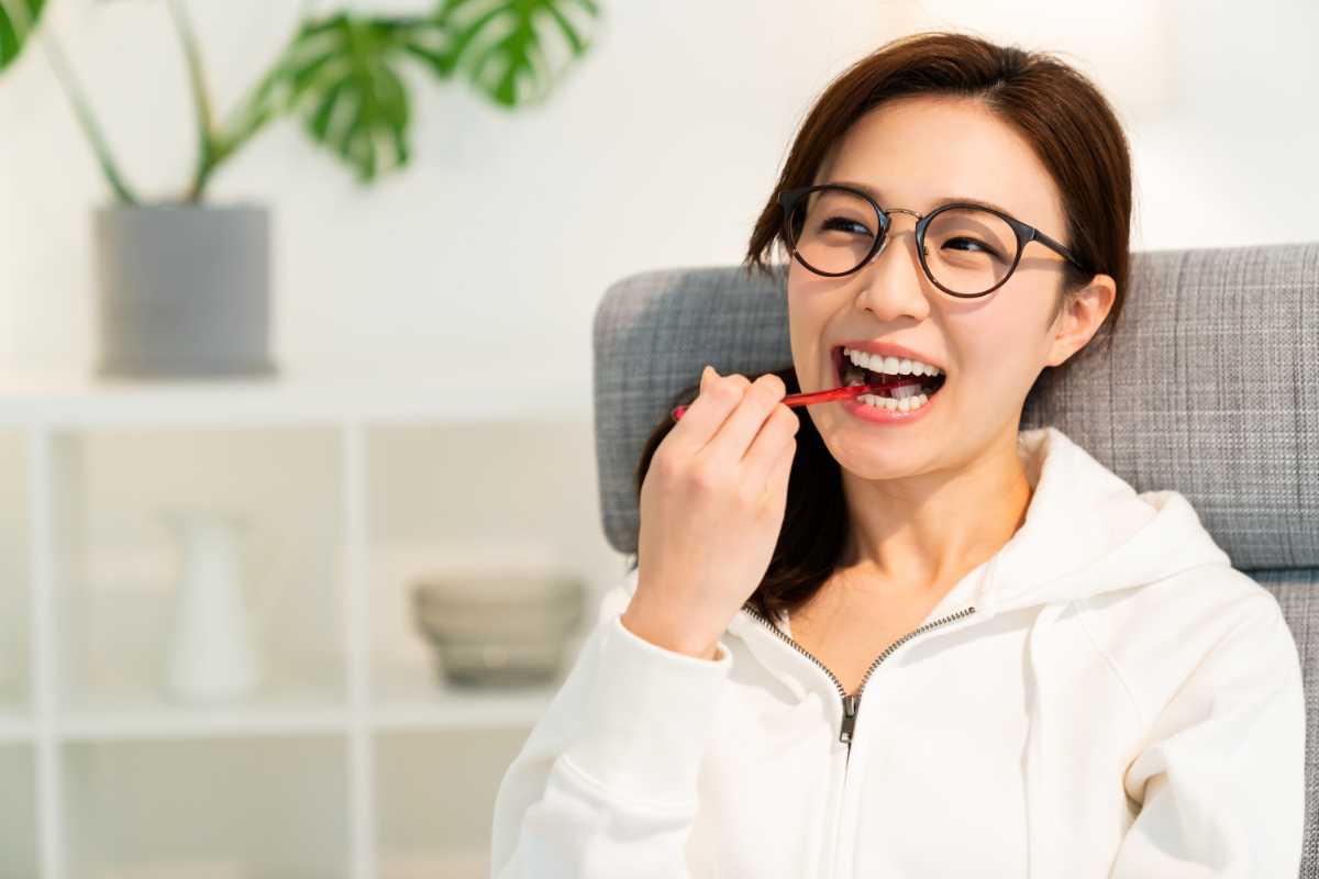 銀歯の下が虫歯になるのを予防するために歯磨きをしている女性